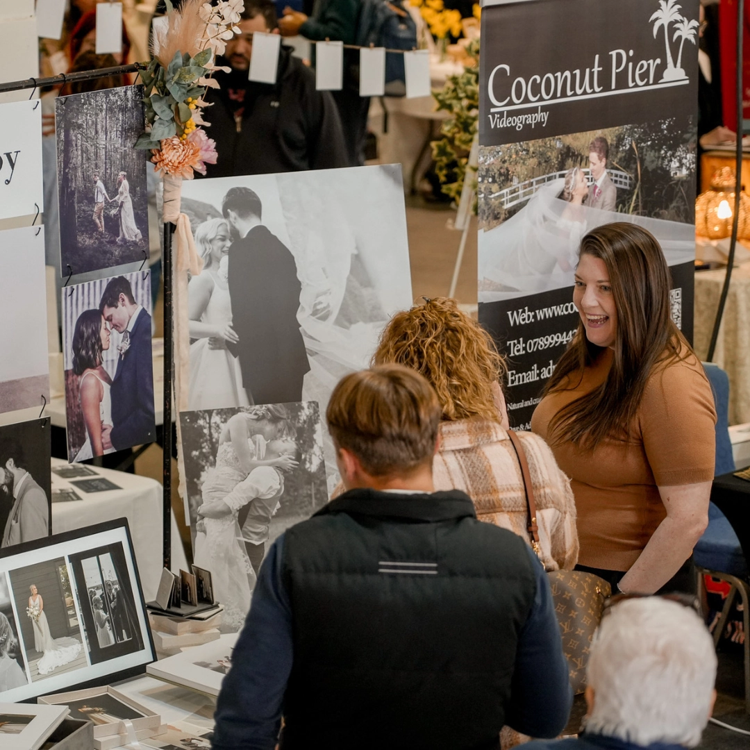 Couple speaking to a wedding supplier at Main Event Wedding Shows